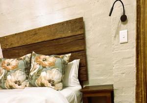 a bedroom with a bed with a wooden headboard and pillows at The Storybook Nook in Kaapsehoop