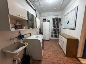 a kitchen with a sink and a washing machine at Pousada Solar de Mayo in Curitiba +44 photos