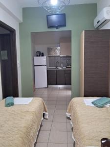 a room with two beds and a kitchen with at Villa Marili in Paralia Katerinis