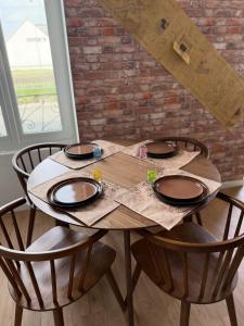 a wooden table with chairs and a brick wall at Appartement dans l'univers Harry Potter in Rosporden +8 photos