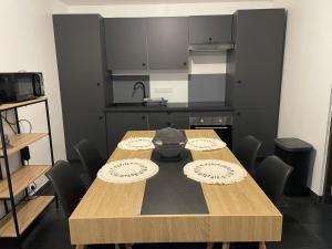 a wooden table in a room with a kitchen at Maison convivial in Vireux-Wallerand
