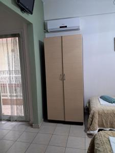 a tall cabinet in a room with two beds at Villa Marili in Paralia Katerinis