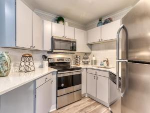 a kitchen with white cabinets and a stainless steel refrigerator at Tranquility Skies MTN View Sauna Jacuzzi MORE in Gatlinburg