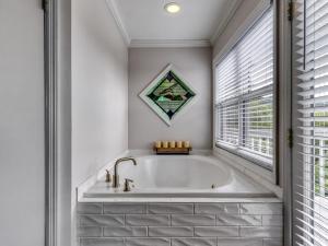 a bath tub in a bathroom with a window at Tranquility Skies MTN View Sauna Jacuzzi MORE in Gatlinburg +24 photos