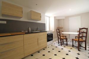 a kitchen with wooden cabinets and a table and chairs at Chambre n2 Maison dHôtes de Charme in Maizières +9 photos