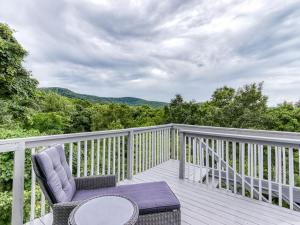 a balcony with a chair and a table on a deck at Tranquility Skies MTN View Sauna Jacuzzi MORE in Gatlinburg