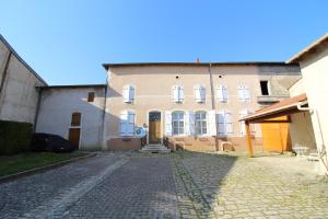 a building with a cobblestone street in front of it at Chambre n2 Maison dHôtes de Charme in Maizières