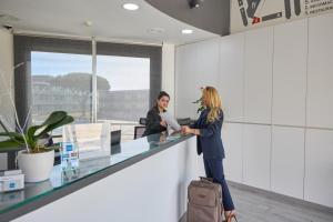 two women standing at a counter in an office at Aparthotel Comtat Sant Jordi in Platja d'Aro +68 photos