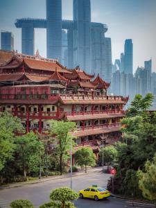 a yellow car parked in front of a large building at Wave Nest 汐宿 in Chongqing