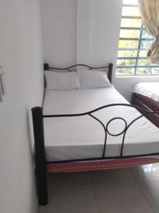 a bed with a black frame in a room with a window at San Alejo in San Joaquín +6 photos