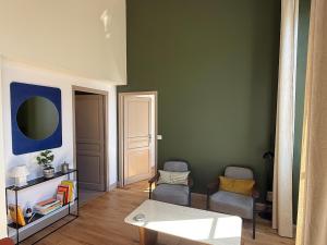 a living room with green walls and a table and chairs at Appartement calme et lumineux au cœur d'Arles in Arles +9 photos