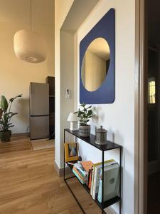 a room with a table with a mirror on the wall at Appartement calme et lumineux au cœur d'Arles in Arles