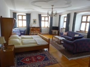 a living room with a bed and a couch and chairs at Schloß-Hotel Hirschau in Hirschau