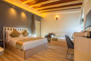a bedroom with a bed and a desk with a chair at Coconut Tree Hulhuvilla Beach in Hulhumale