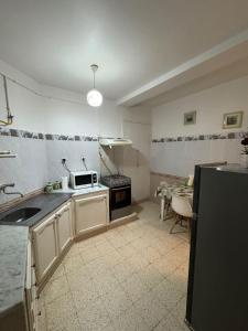 a kitchen with a sink and a microwave at Appartement T3 équipé à Biskra in Biskra