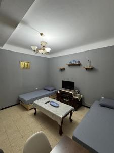a living room with two beds and a table at Appartement T3 équipé à Biskra in Biskra