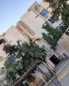 a tall building with trees in front of it at Appartement T3 équipé à Biskra in Biskra