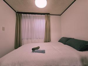 a bedroom with a bed with a book on it at Tokyo Nukumori Lodge in Tokyo +66 photos