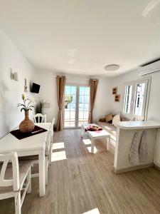 a white living room with a table and a couch at Costa Mernorca in Son Xoriguer