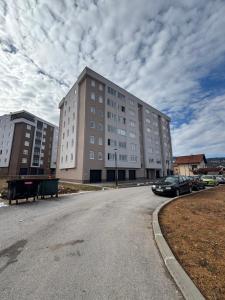 a large building with a car parked in front of it at Apartman MARIJA in Pale
