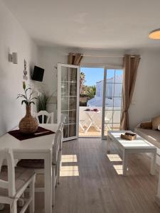 a white living room with a table and a couch at Costa Mernorca in Son Xoriguer