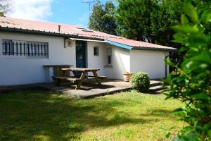 a picnic table in front of a white house at Matsya Hostel in Anglet
