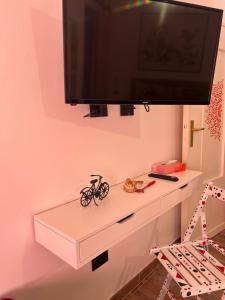 a white dresser with a tv on a wall at Il melograno in Usini