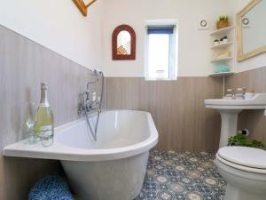 a bathroom with a tub and a toilet and a sink at Postman's Cottage in Bridlington +44 photos