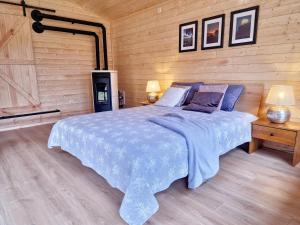 a bedroom with a large bed in a wooden wall at Szalejówka Domki in Kłodzko