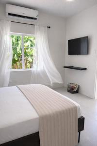 a white bedroom with a bed and a window at Rivers End Guesthouse in Hope Bay +32 photos