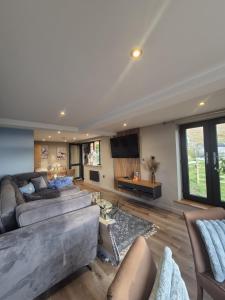 a large living room with couches and a table at The Wellsprings Lodges and Restaurant in Clitheroe