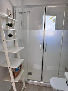 a bathroom with a shower and white shelves at Costa Mernorca in Son Xoriguer +13 photos