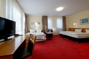 a hotel room with two beds and a flat screen tv at Jägerheim in Nuremberg