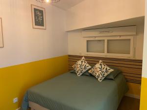 a bedroom with a bed with two pillows on it at Au petit lavoir in Trévières