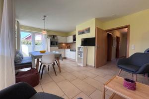a kitchen and living room with a table and chairs at DHH Wald in Kellenhusen
