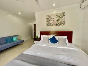 a bedroom with a large white bed and a blue couch at private villa with private pool in Aborlan +40 photos