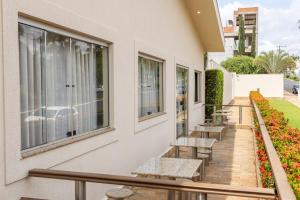 a balcony with benches and tables on a building at Candeias Hotel in Batatais