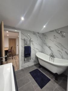 a bathroom with a white tub and a sink at The Wellsprings Lodges and Restaurant in Clitheroe +40 photos