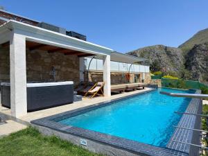 a swimming pool with a patio and a house at Villa Rokka Luxe - Free Private Heated Pool, Hot Tub, and more in Kissamos