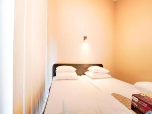 a bedroom with a bed with white sheets and pillows at Bollen in Oud-Ade