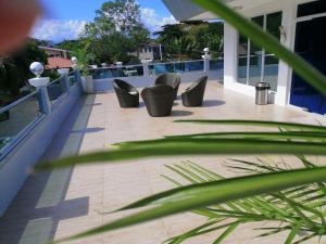 a balcony with a row of chairs on a roof at private villa with private pool in Aborlan
