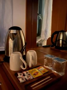a counter with a coffee pot and cups on it at Mk Big boss otel in Erzurum