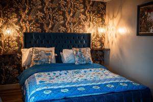 a bedroom with a bed with a blue comforter at The Wellsprings Lodges and Restaurant in Clitheroe