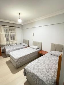 a room with three beds and a window at Mk Big boss otel in Erzurum
