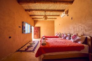 a bedroom with a bed with a red comforter at Land of dreams in Nkob