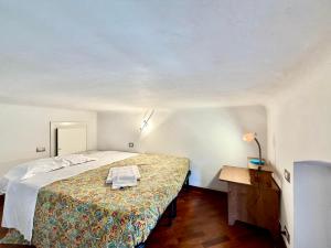ein kleines Schlafzimmer mit einem Bett und einem Tisch in der Unterkunft Cavour in Levanto + 2 Fotos