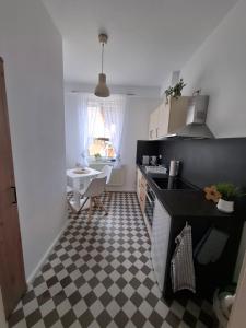 a kitchen with a black and white checkered floor at Wohnung HoMe No 17 in Parchim