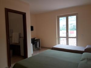 Habitación de hotel con 2 camas y ventana en Il Bel Risveglio, en Atena Lucana