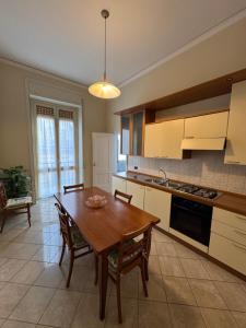 a kitchen with a wooden table and chairs in it at Casa del Corso Apartments in Avola