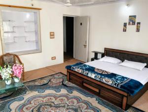 a bedroom with a bed and a window and a rug at The Holt Gardens in Srinagar